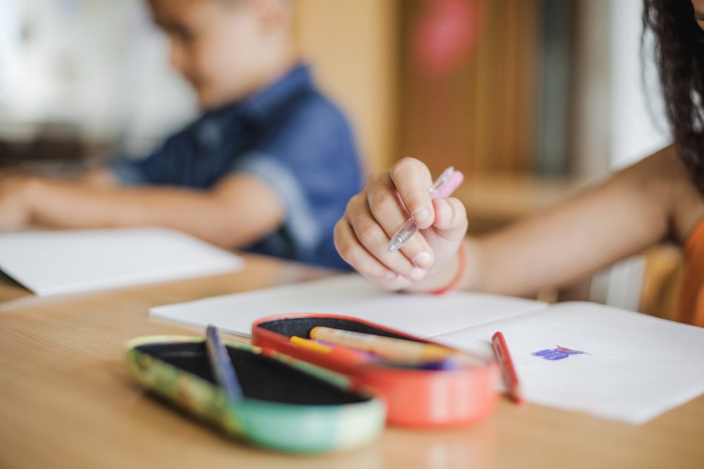 Niña escribiendo en su cuaderno escolar